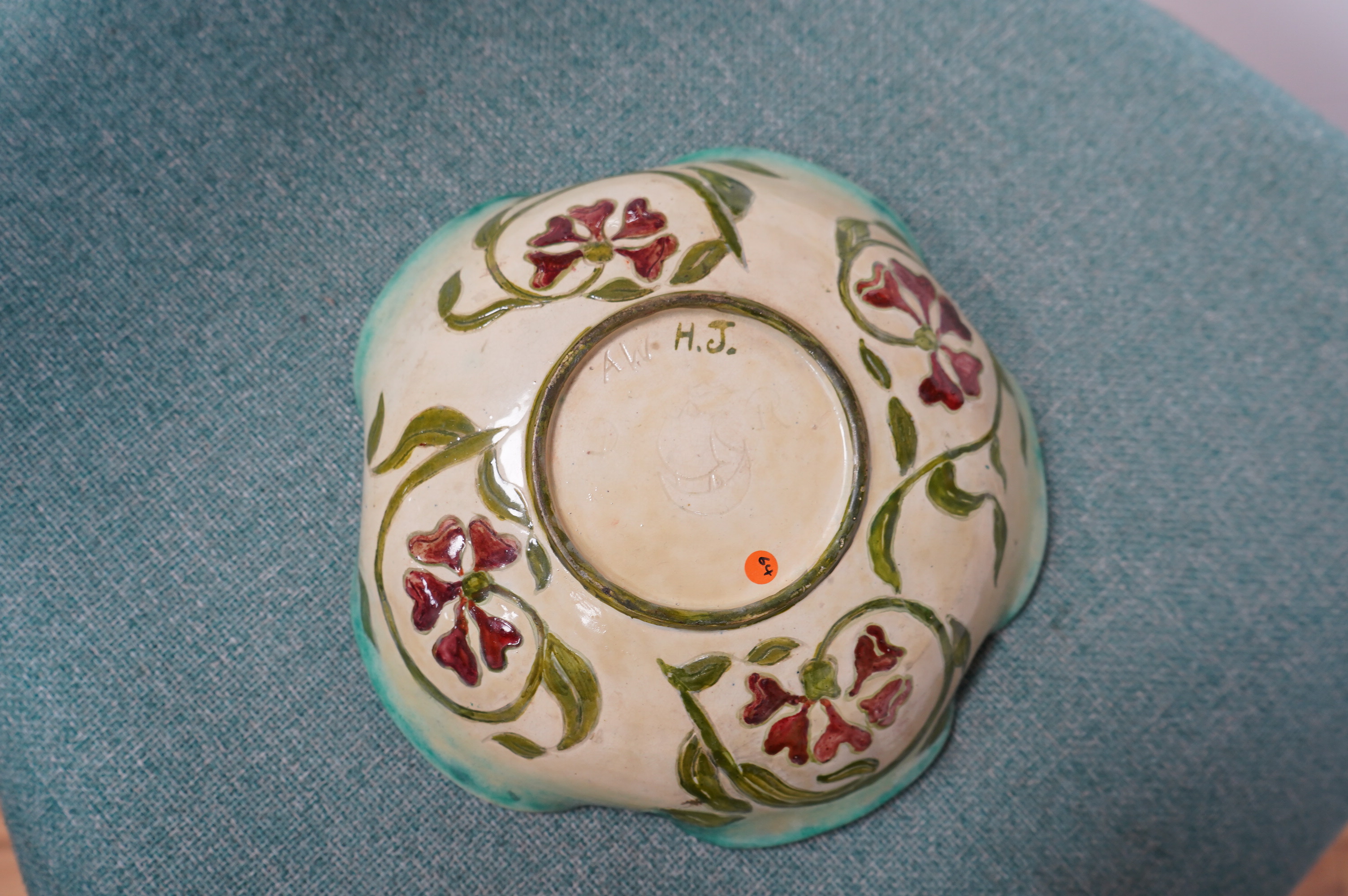 A Della Robbia green glazed floral dish, 19cm diameter. Condition - good.